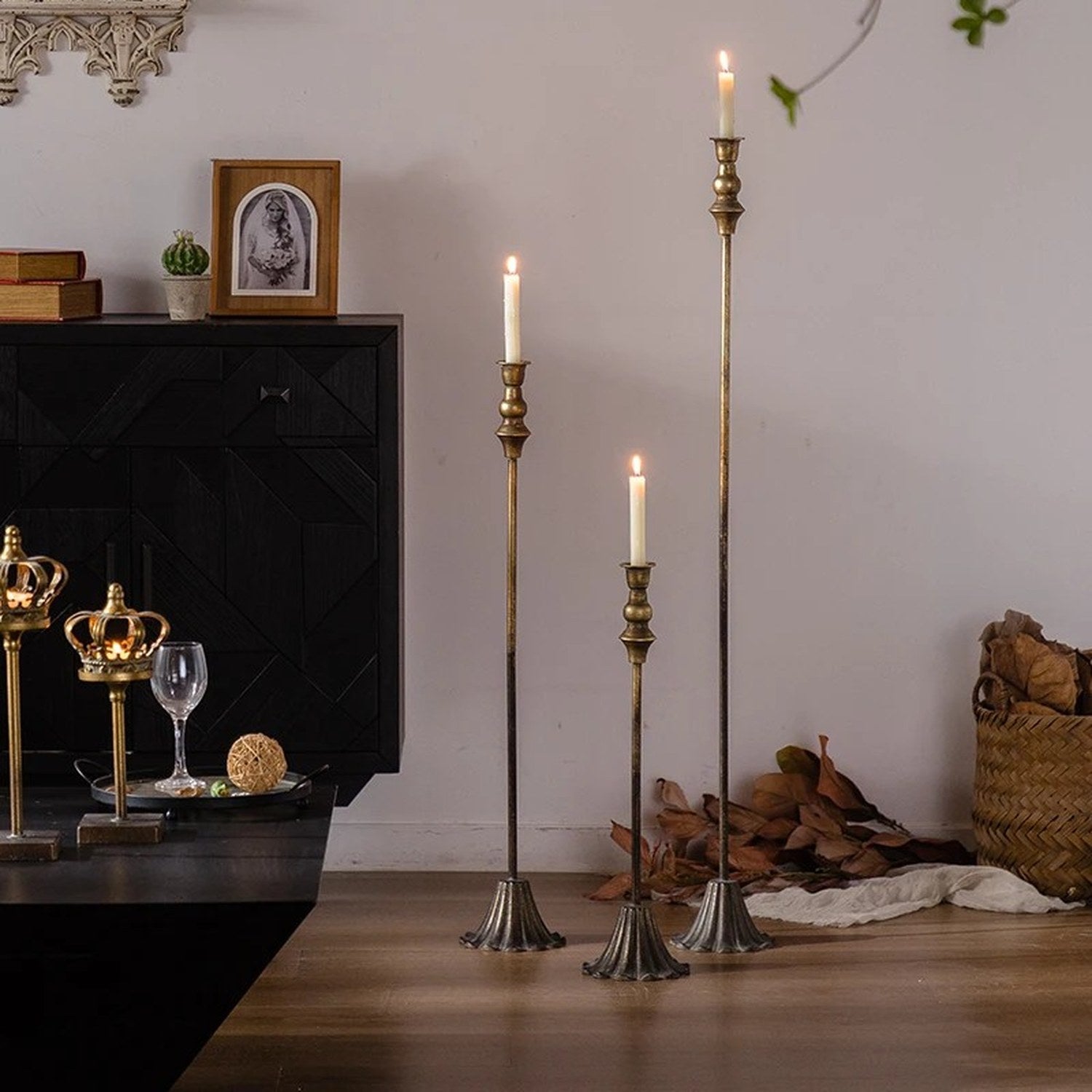 Trio de chandeliers en fer laiton antique dans un salon avec commode noire