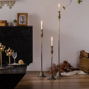 Trio de chandeliers en fer laiton antique dans un salon avec commode noire