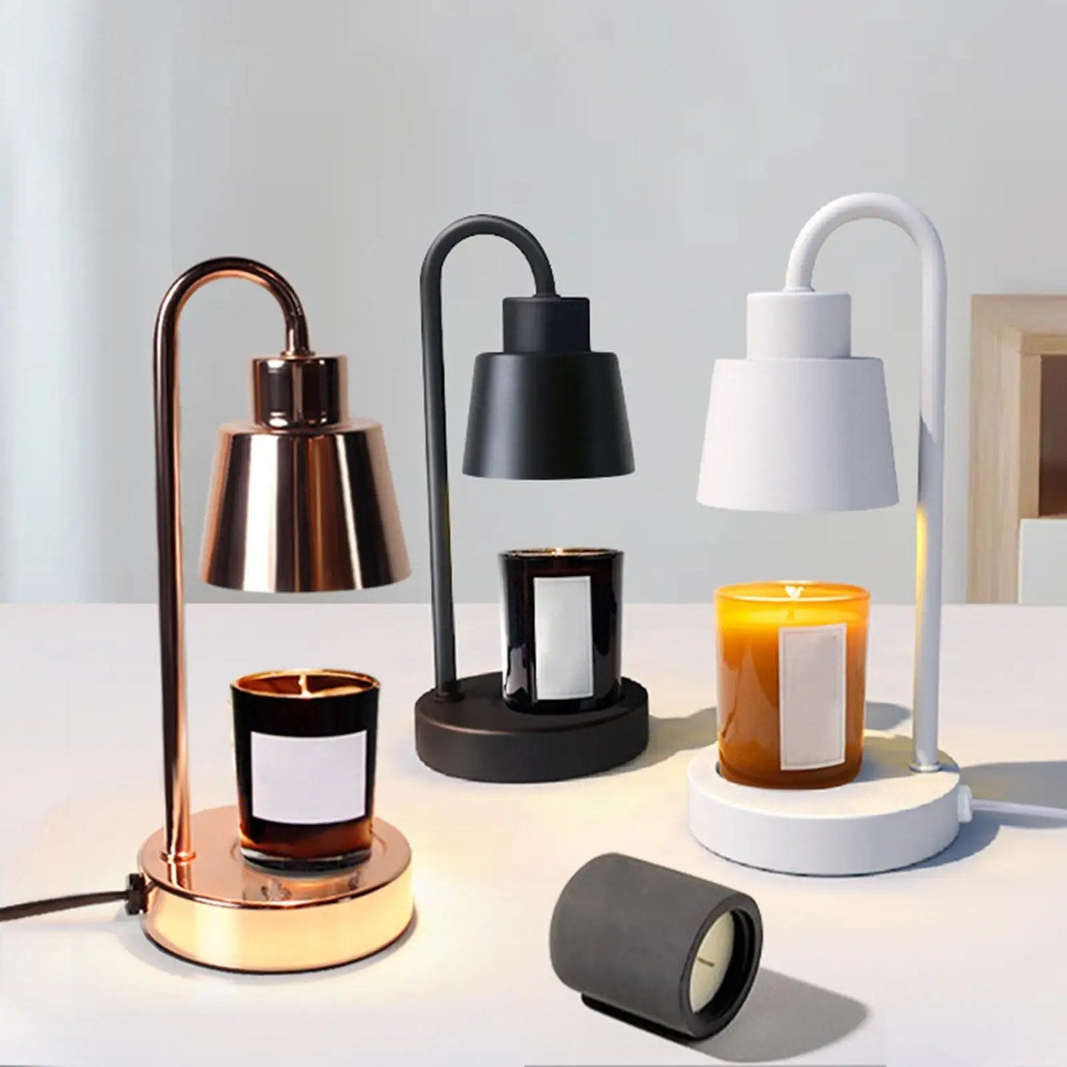 Lampe chauffe-bougie en trois finitions noire blanche et cuivrée avec bougies allumées