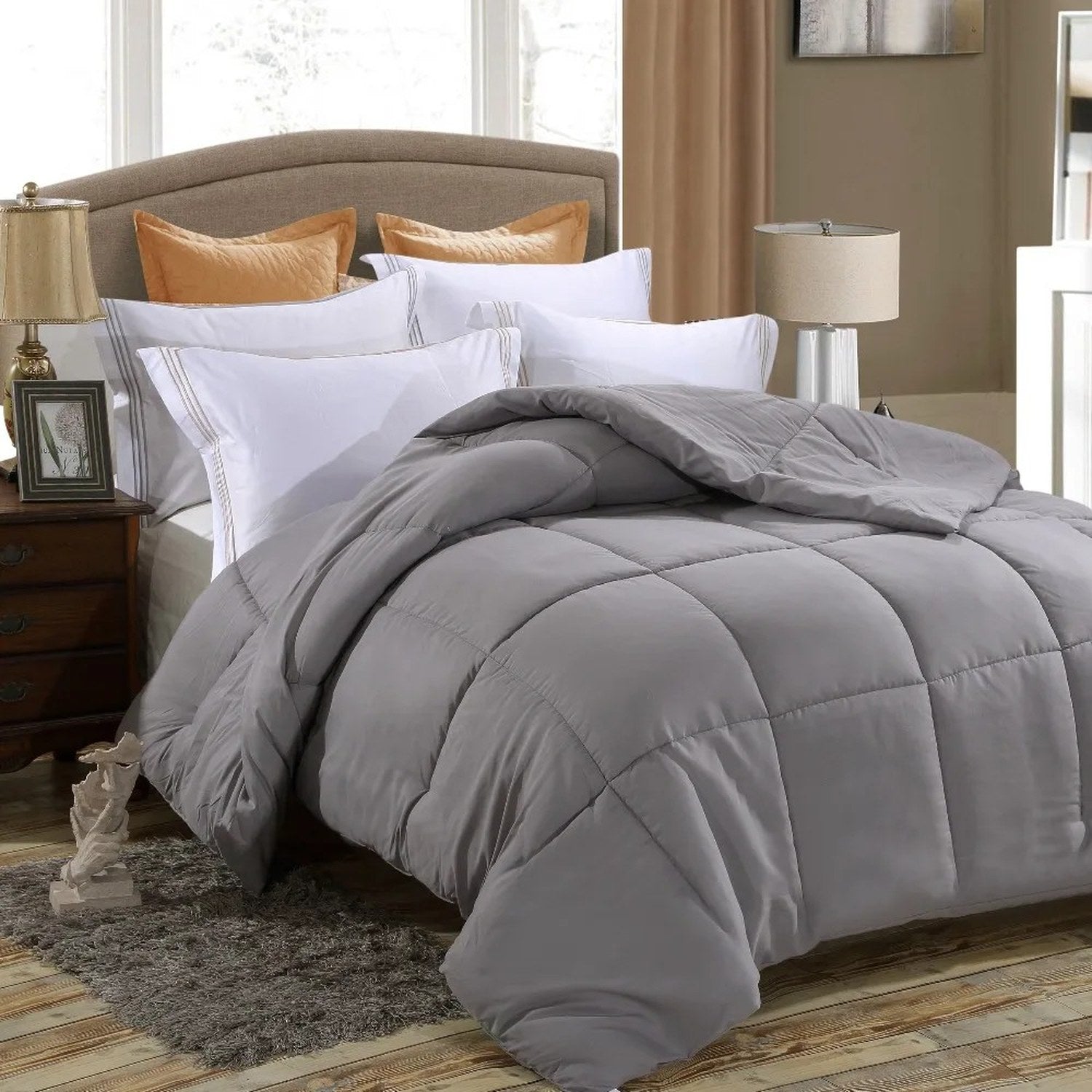 Couette grise posée sur un lit dans une chambre avec tapis