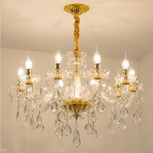 Lustre baroque en cristal doré vu de face sur fond neutre