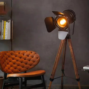 Lampadaire projecteur vintage près d'un fauteuil en cuir cognac capitonné