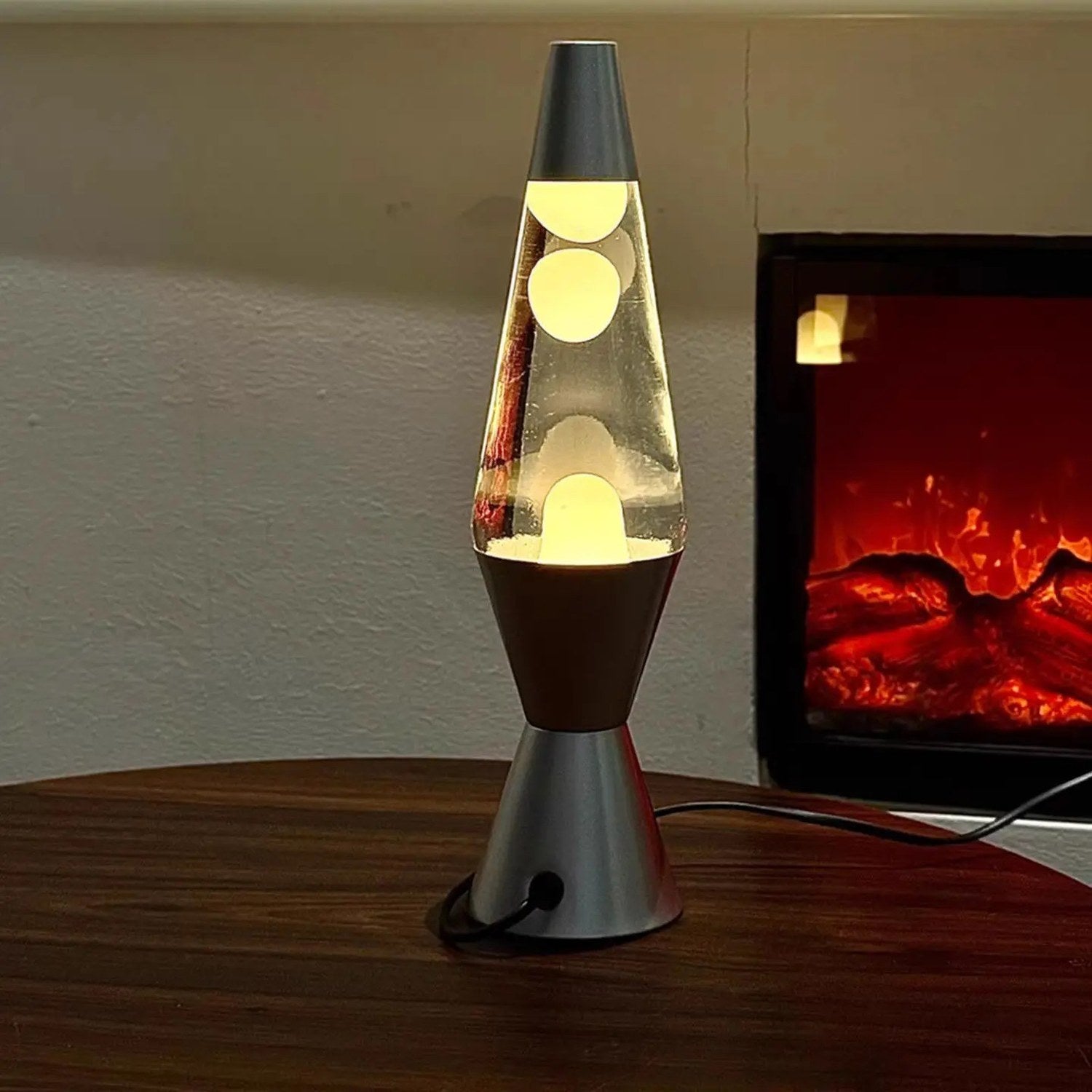 Lampe à lave allumée à la lumière chaude près d'une cheminée