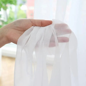 Gros plan sur la texture fine et transparente du voilage blanc