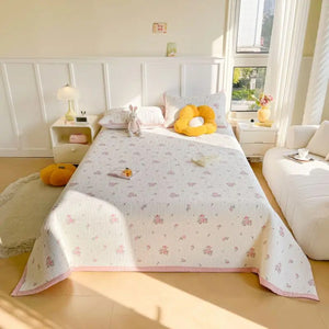 Couvre-lit fleuri vu de profil sur un lit dans une chambre lumineuse