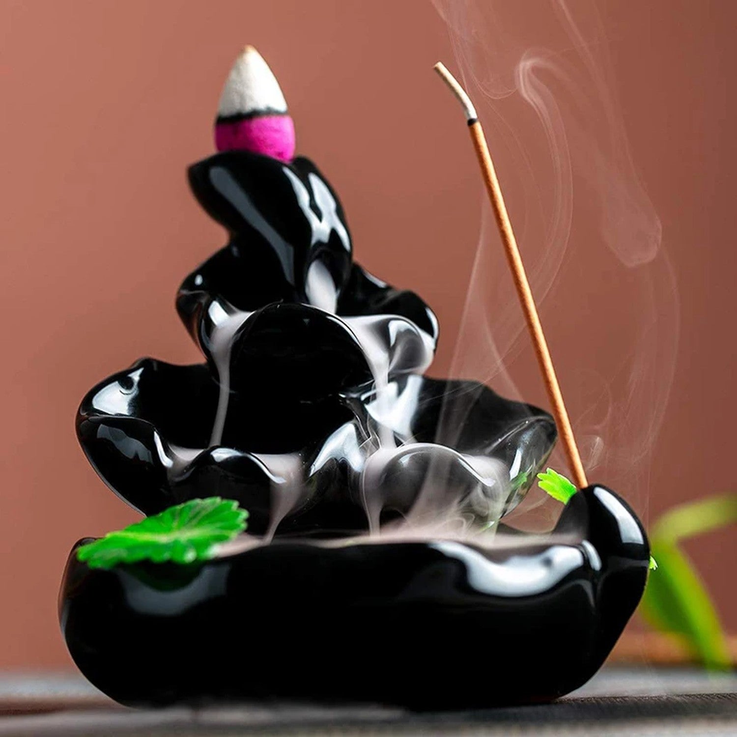 Cascade de fumée d'encens sur brûleur céramique artisanale fond sombre
