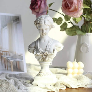 Statue buste classique résine blanc avec roses fraîches et bougie dans intérieur romantique
