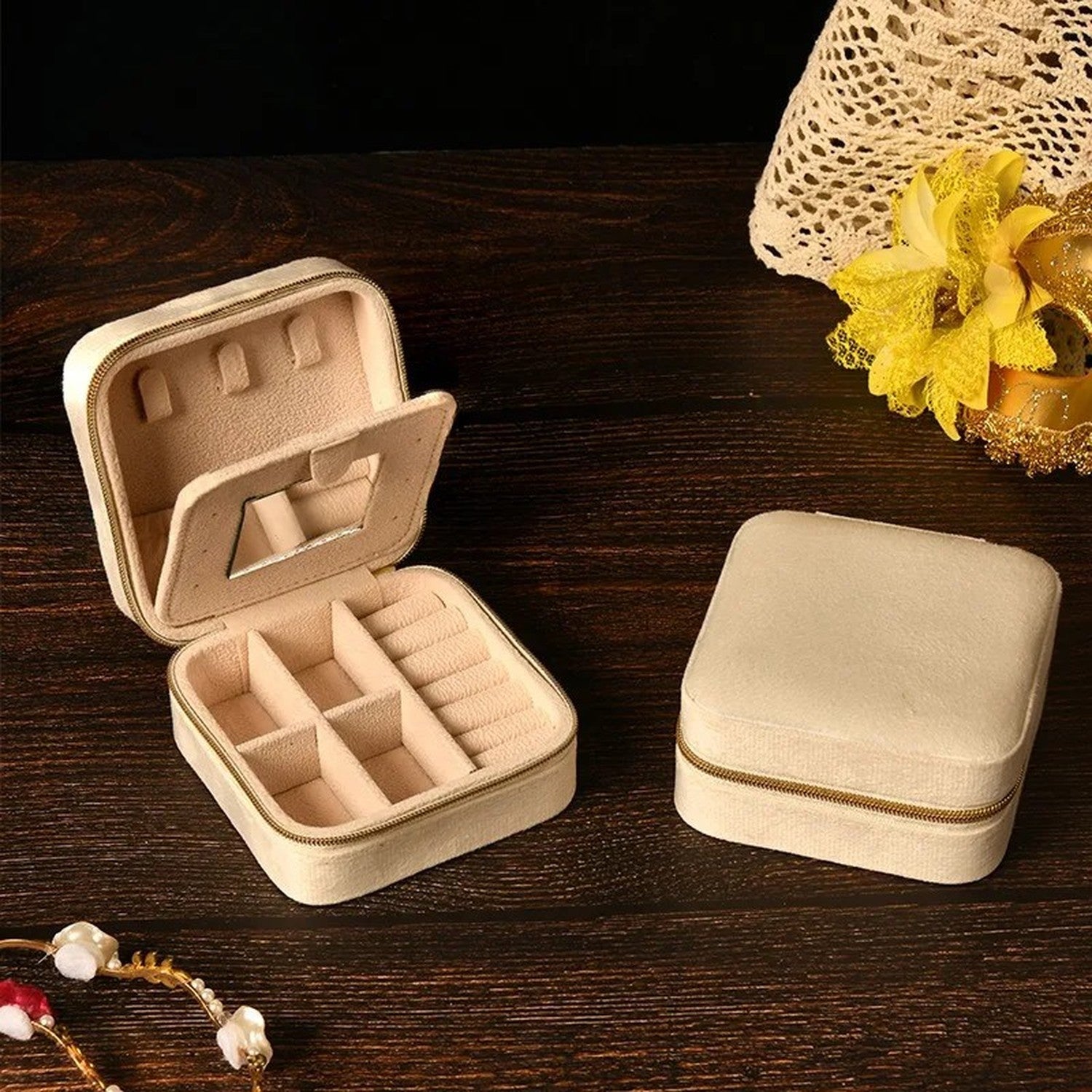 Boîte à bijoux en velours beige ouverte révélant les compartiments et le miroir
