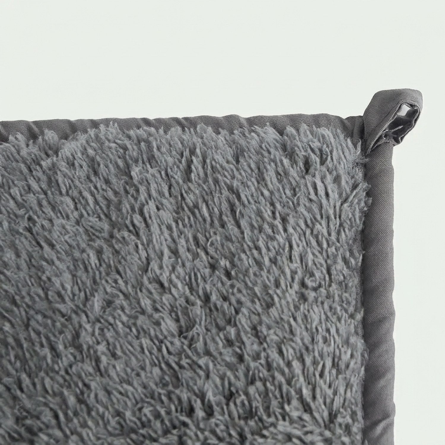 Détail de l'attache de fixation et du tissu moelleux de la couverture lestée
