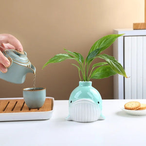 Vase baleine turquoise avec plante verte en situation