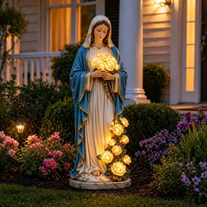 Statue Vierge Marie dans un jardin fleuri près d'une maison en soirée
