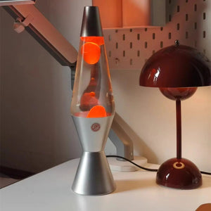 Lampe à lave allumée avec bulles orange sur un bureau