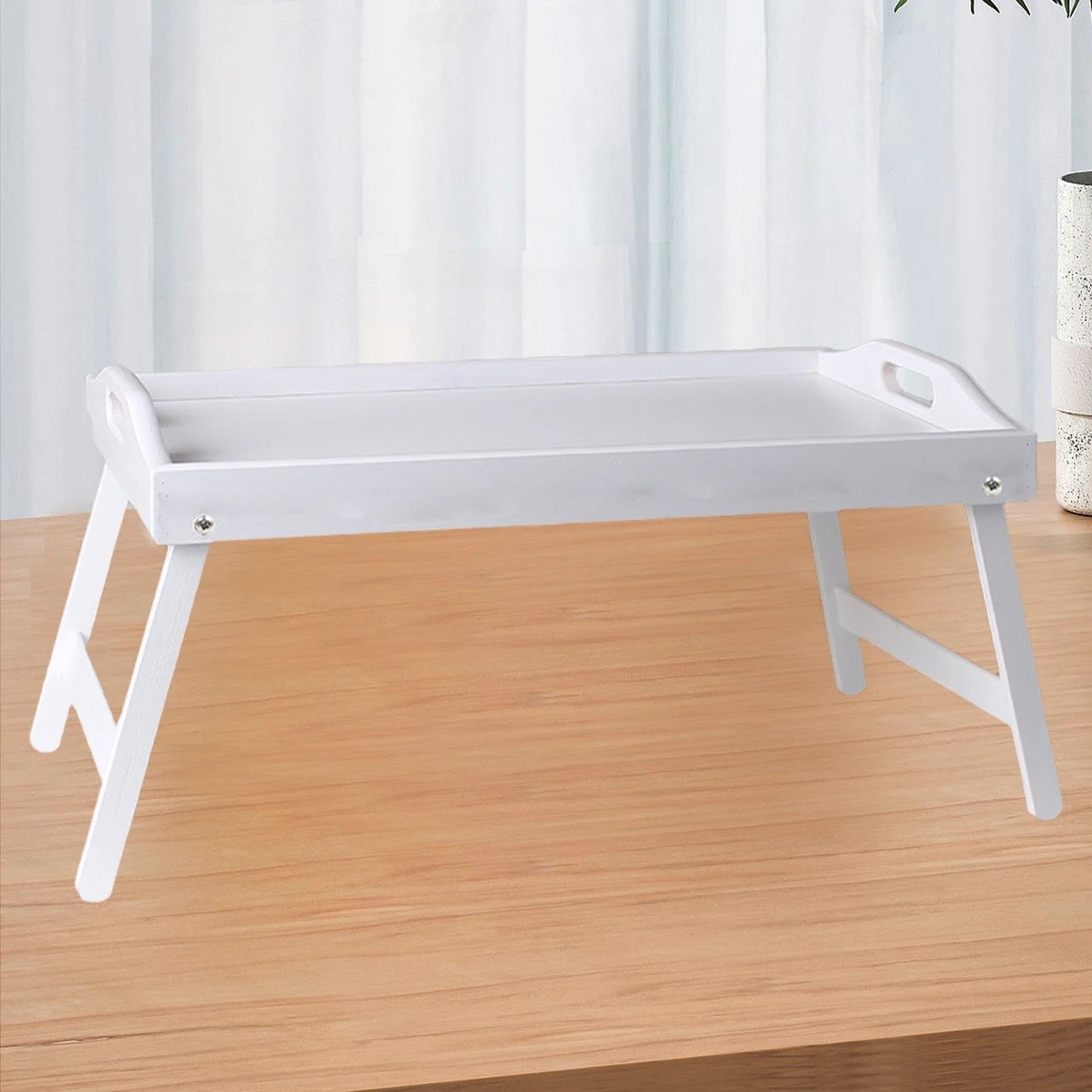 Plateau bambou naturel sur une table en bois près d'une fenêtre avec voilage blanc