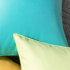 Gros plan sur le tissu et la couture des housses de coussin turquoise et vert clair