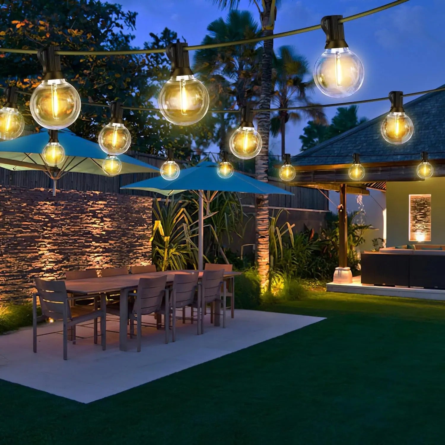 Guirlande lumineuse extérieure guinguette G40 LED installée dans un jardin avec table de repas