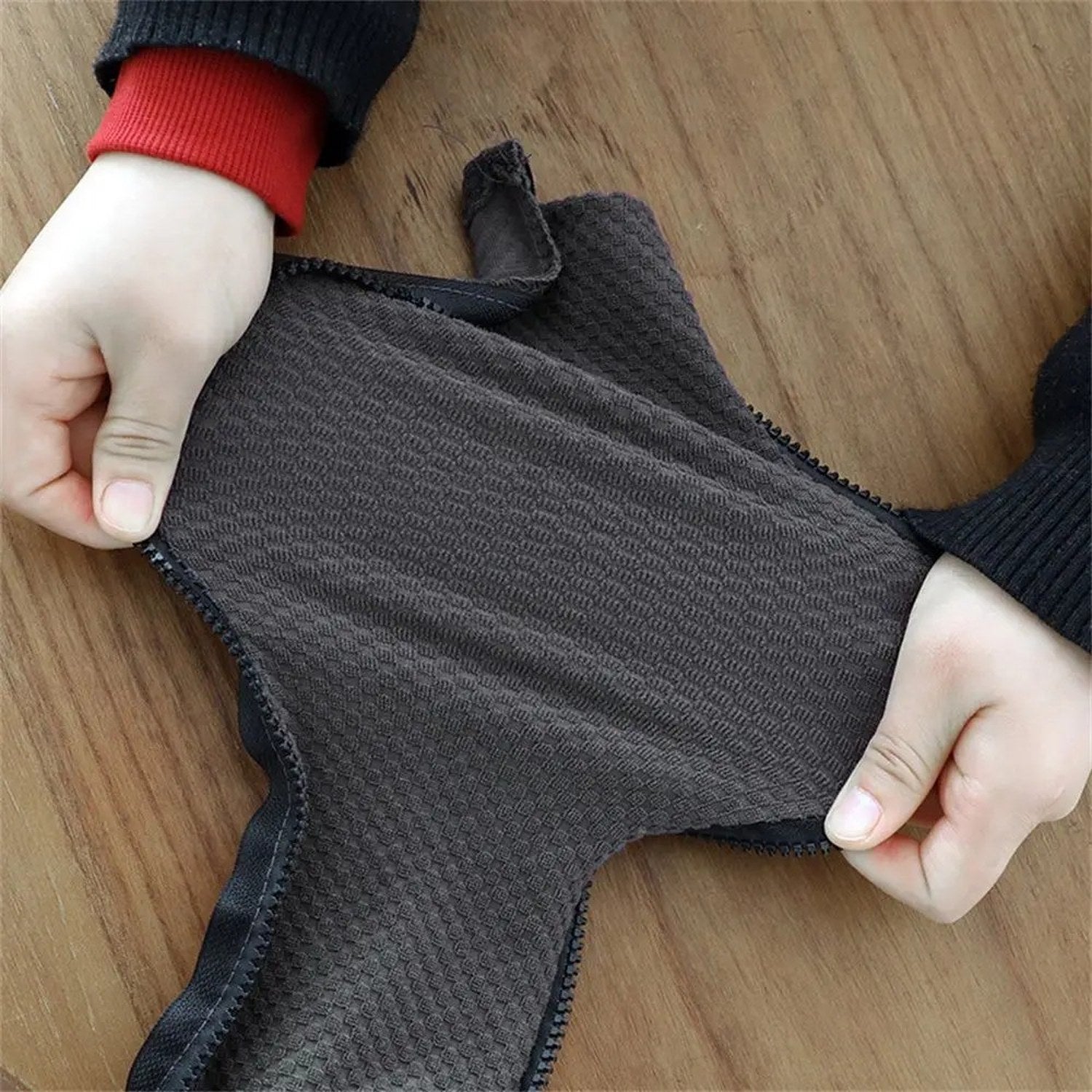 Mains tendant le tissu extensible d'une housse d'accoudoir pour montrer son élasticité