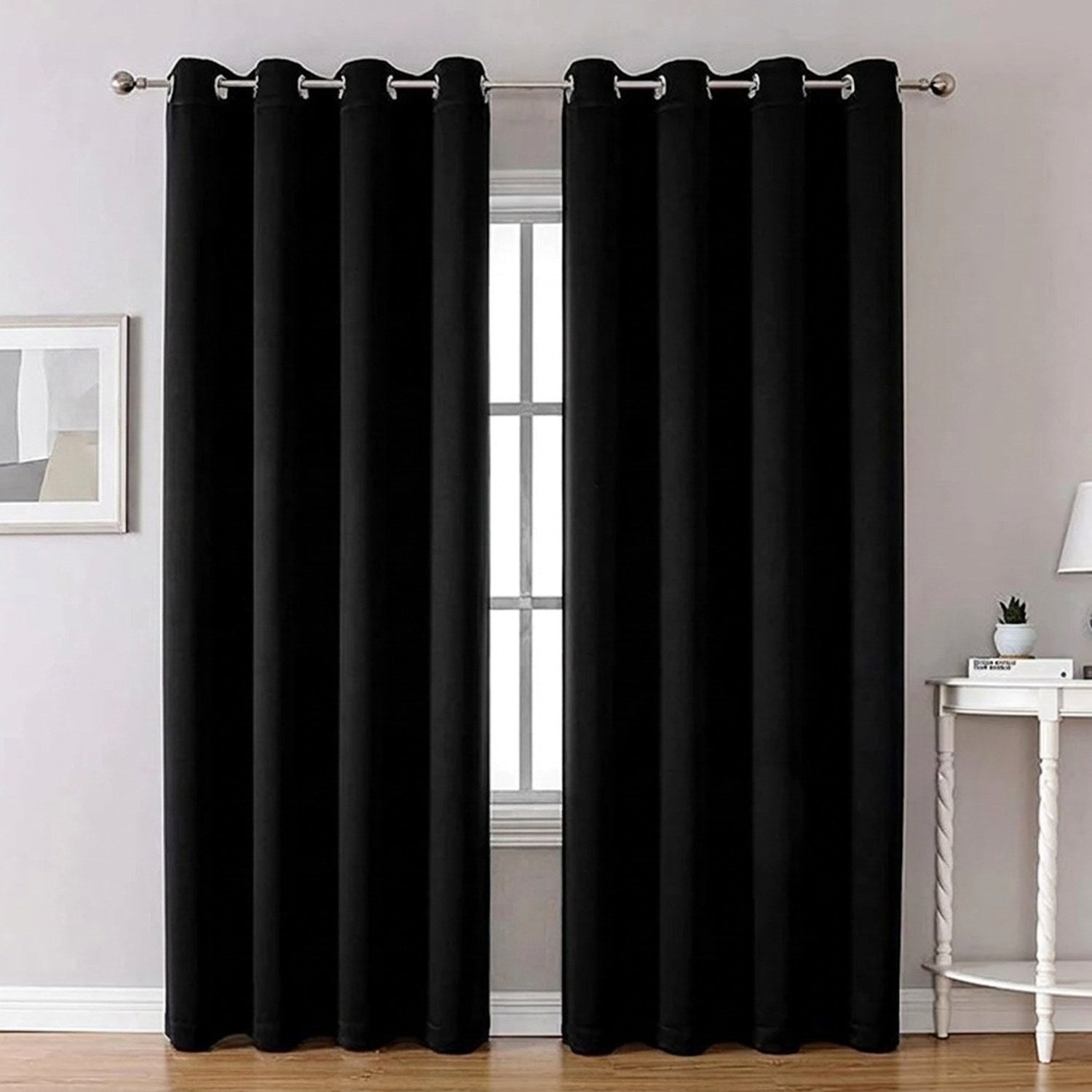 Rideau noir occultant thermique suspendu à une tringle devant une fenêtre