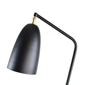 Détail de l'abat-jour conique noir et du bras orientable en laiton