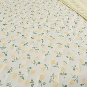 Gros plan du tissu matelassé à imprimé fleuri jaune