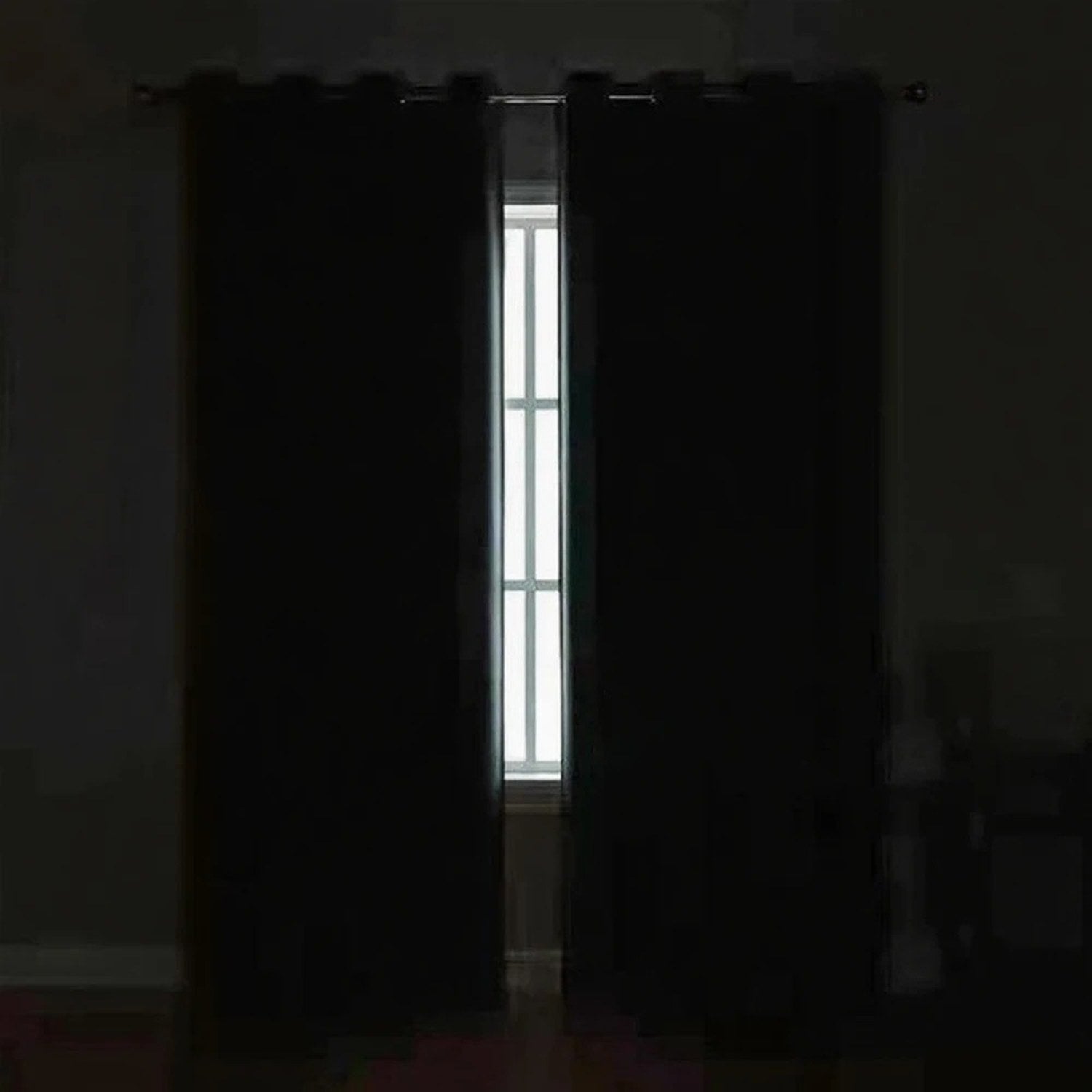 Chambre plongée dans l'obscurité totale grâce au rideau occultant fermé