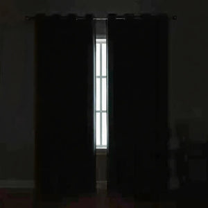 Chambre plongée dans l'obscurité totale grâce au rideau occultant fermé