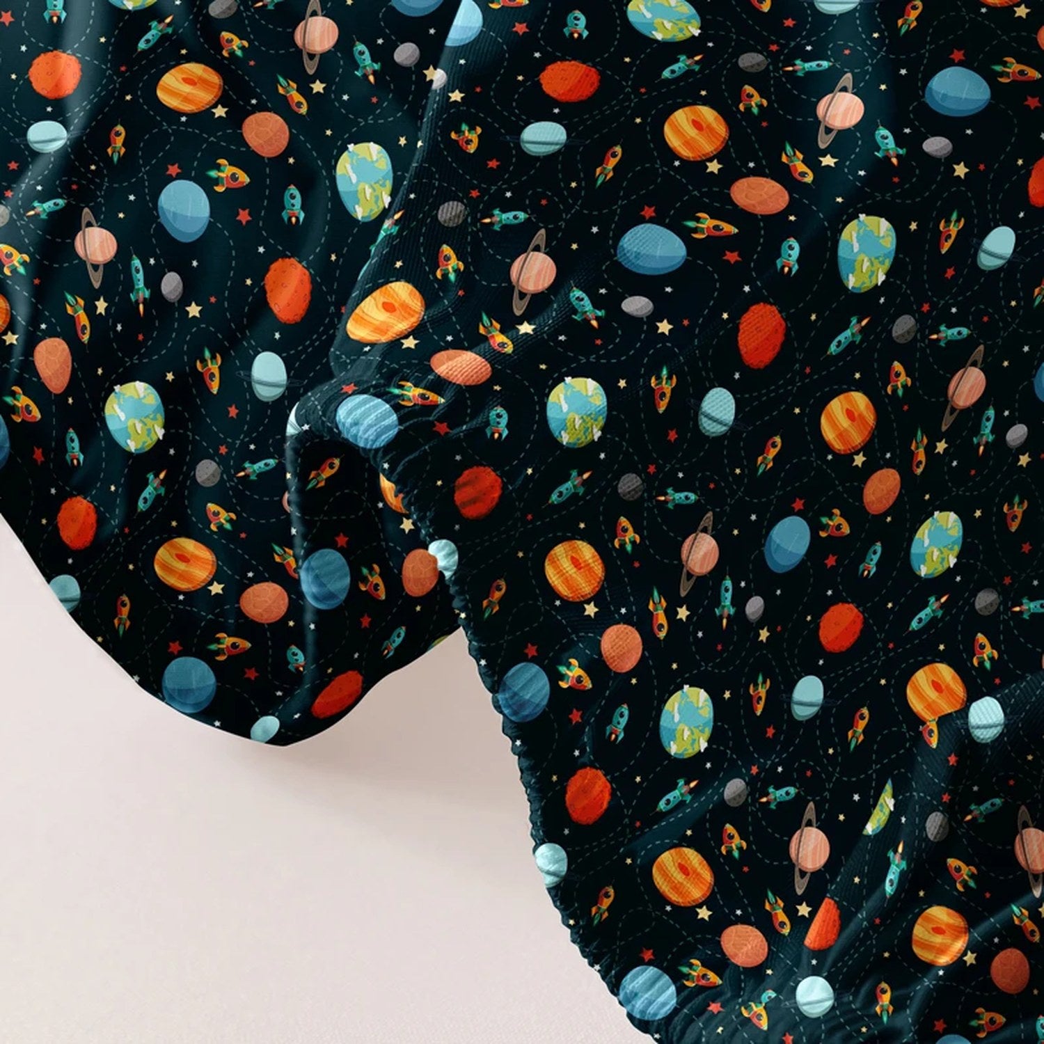 Gros plan du tissu imprimé cosmos du drap housse avec planètes colorées