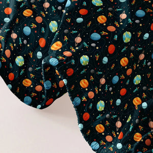 Gros plan du tissu imprimé cosmos du drap housse avec planètes colorées