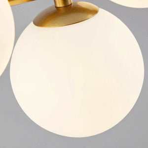 Gros plan sur un globe en verre opalin et sa fixation dorée