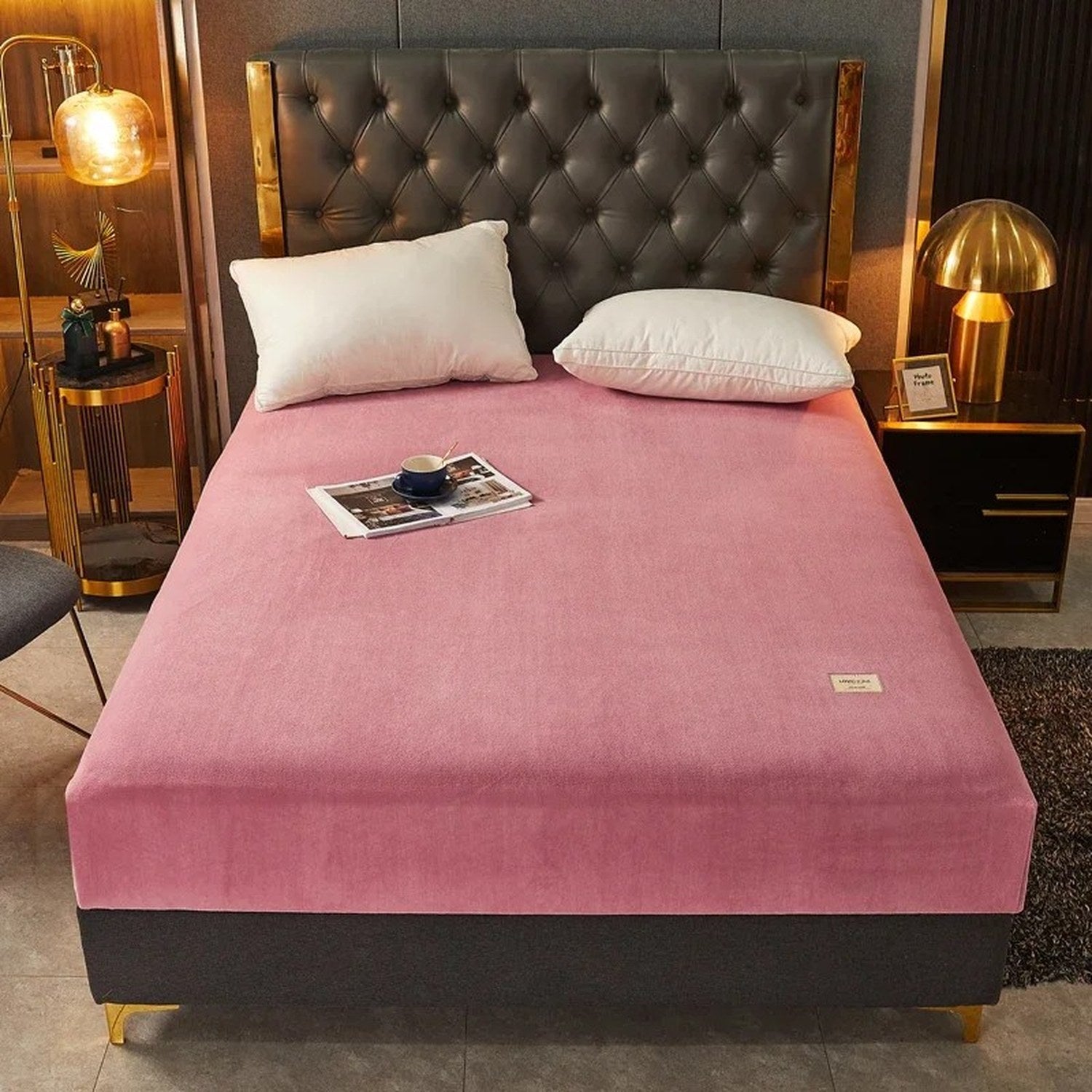 Drap-housse rose installé sur un lit dans une chambre élégante