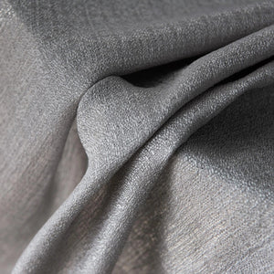 Vue rapprochée des plis et de la texture du tissu gris