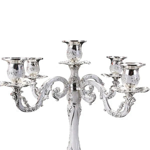 Gros plan des bras en volute du chandelier 5 bras argenté, coupes tulipes ciselées