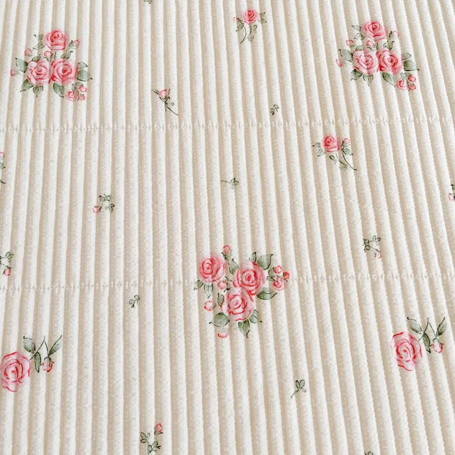 Détail du tissage matelassé et des motifs floraux roses