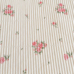 Détail du tissage matelassé et des motifs floraux roses
