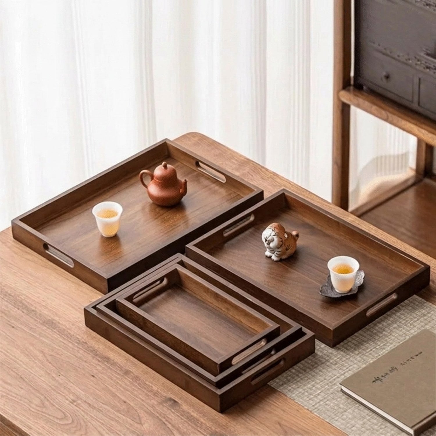 Cinq plateaux bambou noyer de différentes tailles présentés sur table en bois