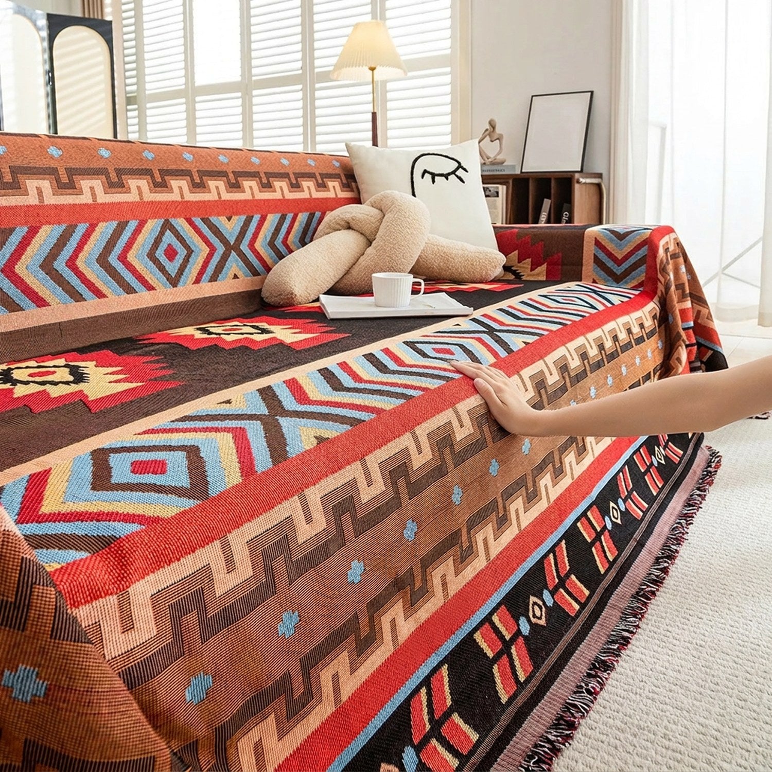 Couvre-lit amérindien aztèque drapé sur un canapé avec pompons et détails tissés