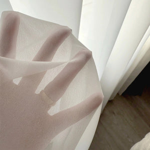 Gros plan d'une main visible à travers le tissu voile transparent