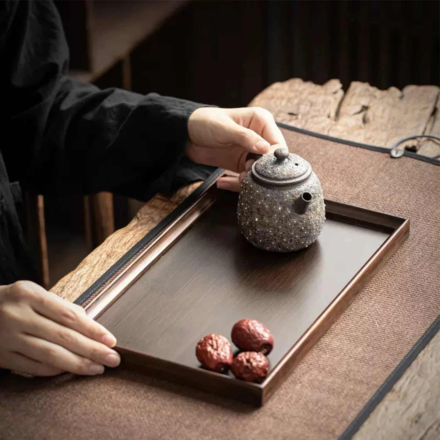 Plateau bambou tenu avec théière et fruits
