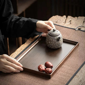 Plateau bambou tenu avec théière et fruits