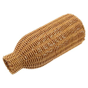 Vase en rotin tressé couché révélant la texture du rotin naturel