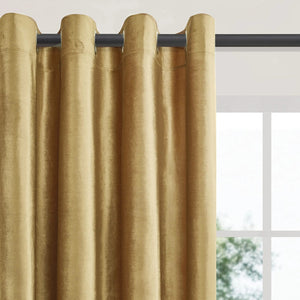 Détail des œillets métalliques du rideau doré glissés sur une tringle noire