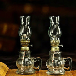 Deux lampes à pétrole en verre transparent avec poignée sur fond noir