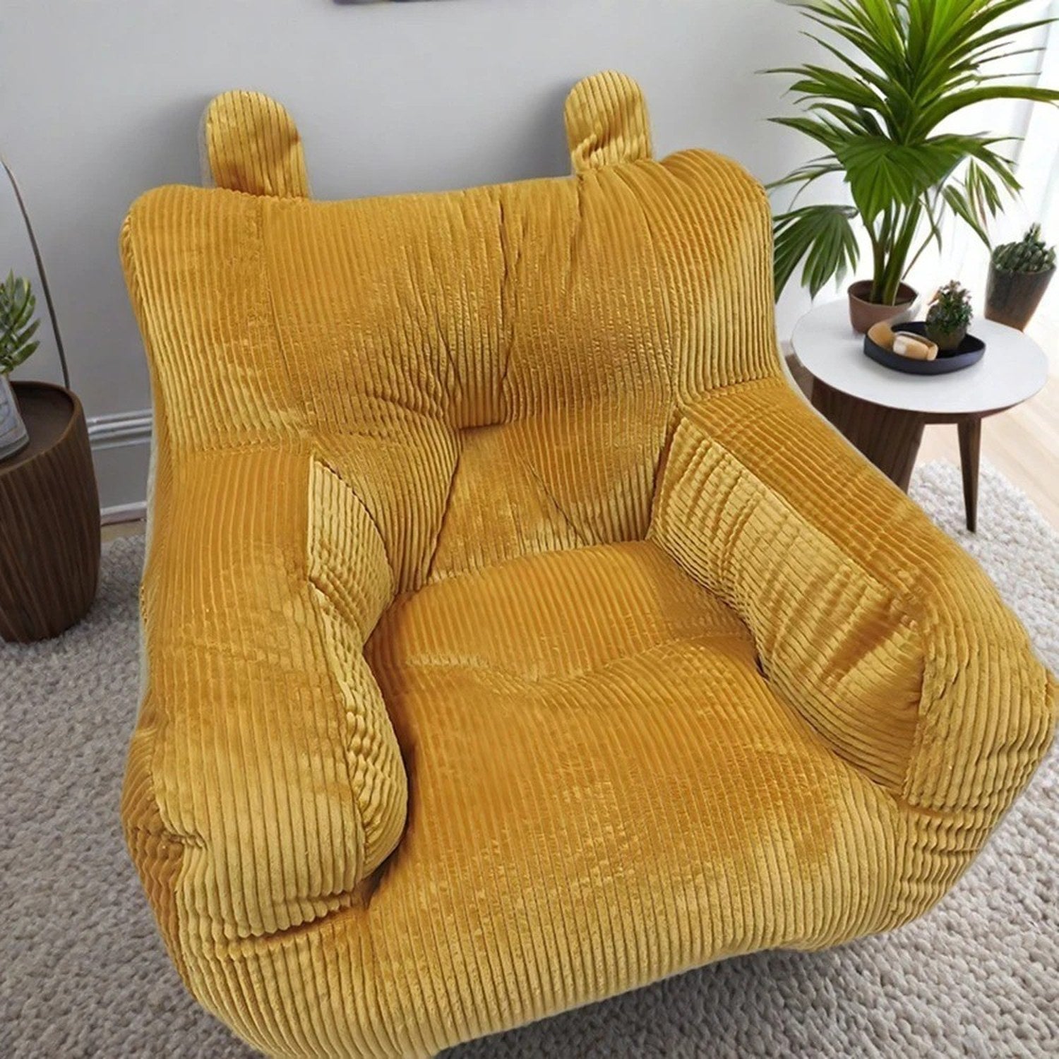 Pouf mini canapé enfant coloris orange doré dans un salon avec plante verte