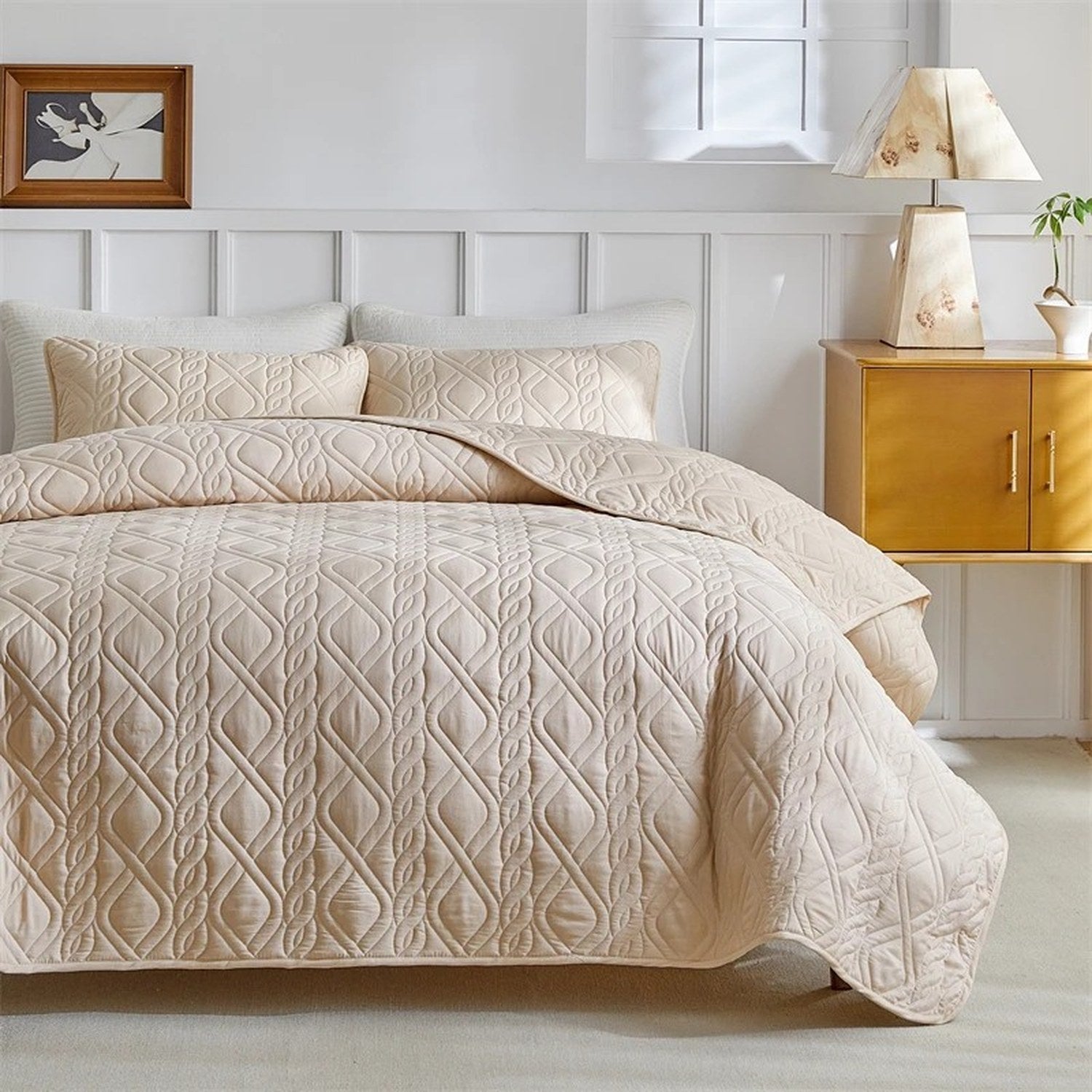 Vue complète du couvre-lit beige matelassé sur un lit