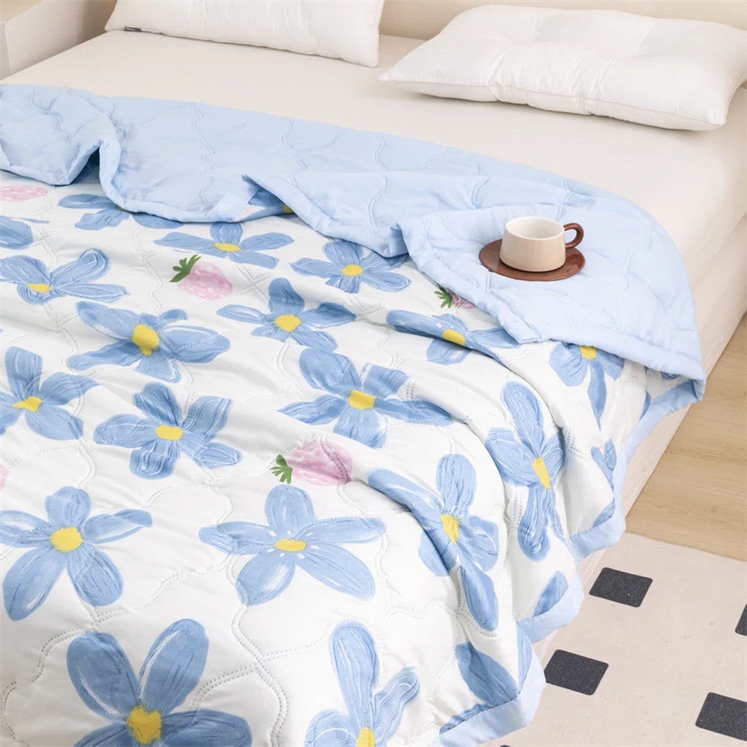 Vue complète de la couverture d'été à motif floral bleu sur un lit