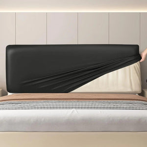 Housse de tête de lit noire dans une chambre avec applique murale et bougie