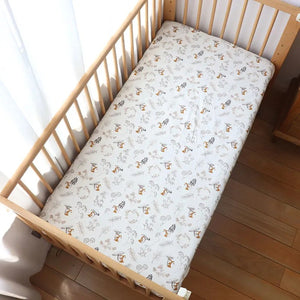 Vue rapprochée du drap housse bébé motif champignons et renards sur un matelas de berceau