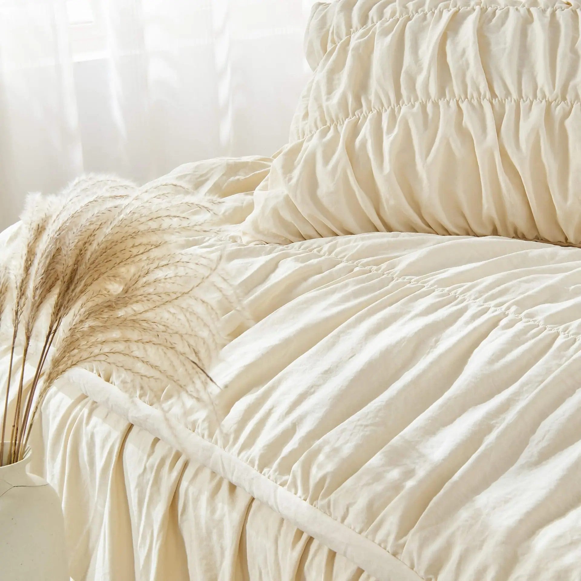 Gros plan sur la texture froissée de la parure de lit bohème chic avec pampas décoratifs