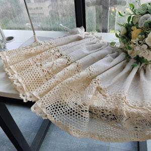 Détail du tissu en lin beige et de la dentelle crochet du rideau court