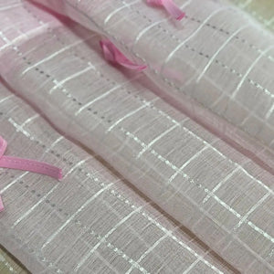 Macro de la maille tulle rose montrant le tissage à carreaux blancs