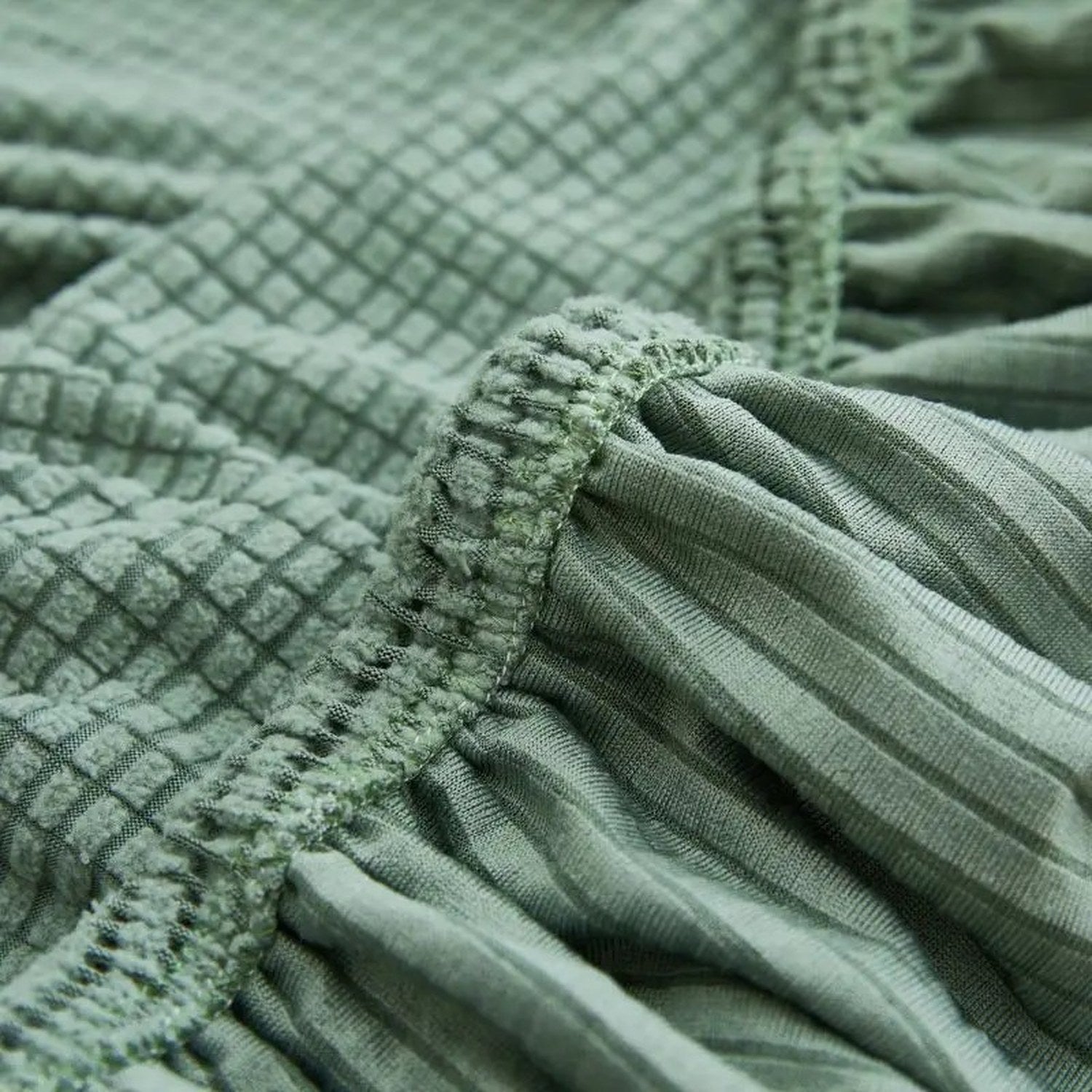 Gros plan sur le tissu jacquard texturé et la bande élastique de la housse de canapé